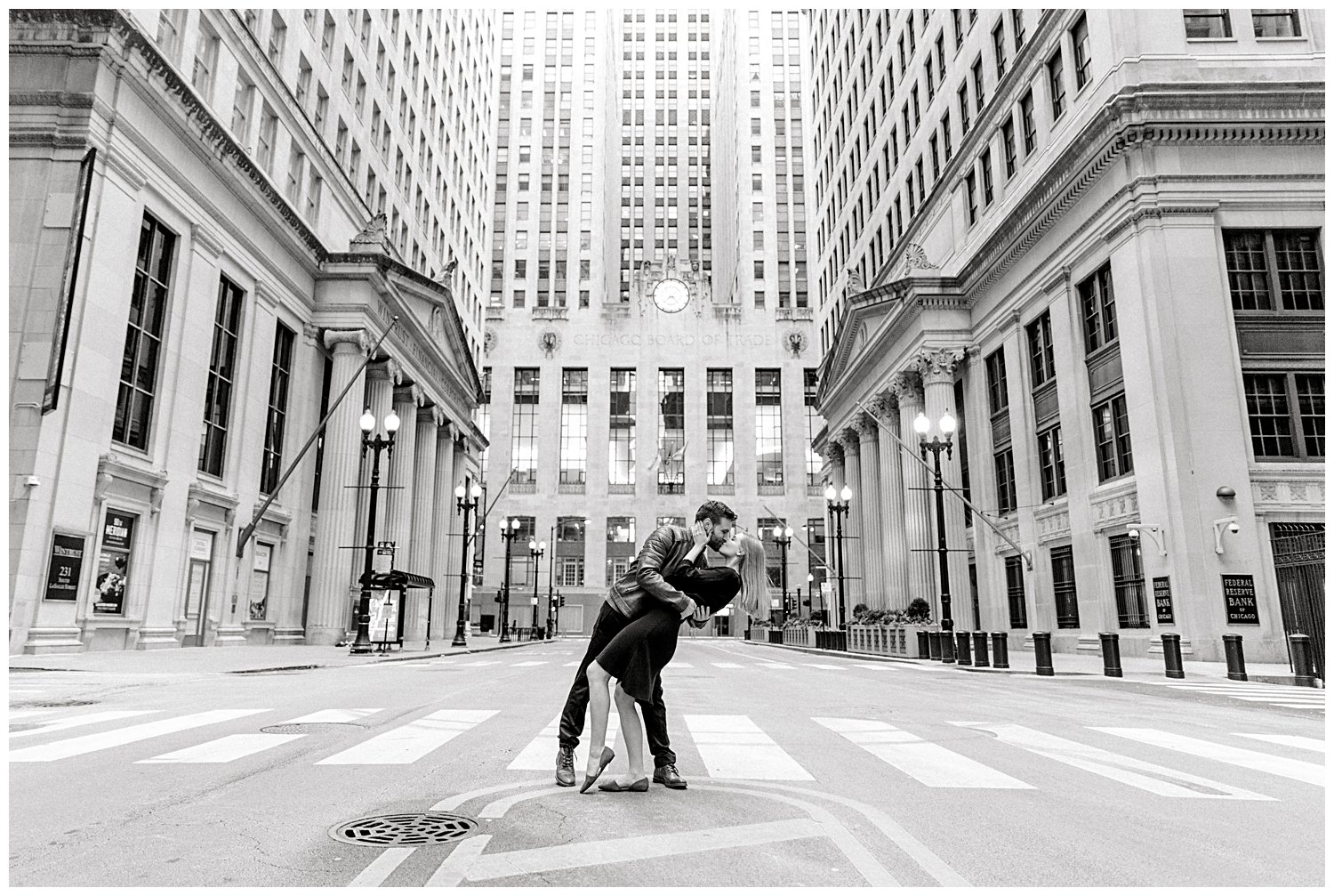 Couple posing for engagement photos outside the Chicago Board of Trade Building