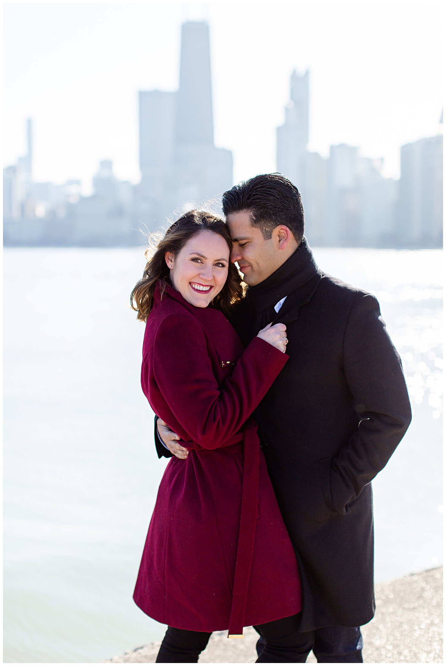 couple smiling at camera for their engagement session at north avenue beach in chicago