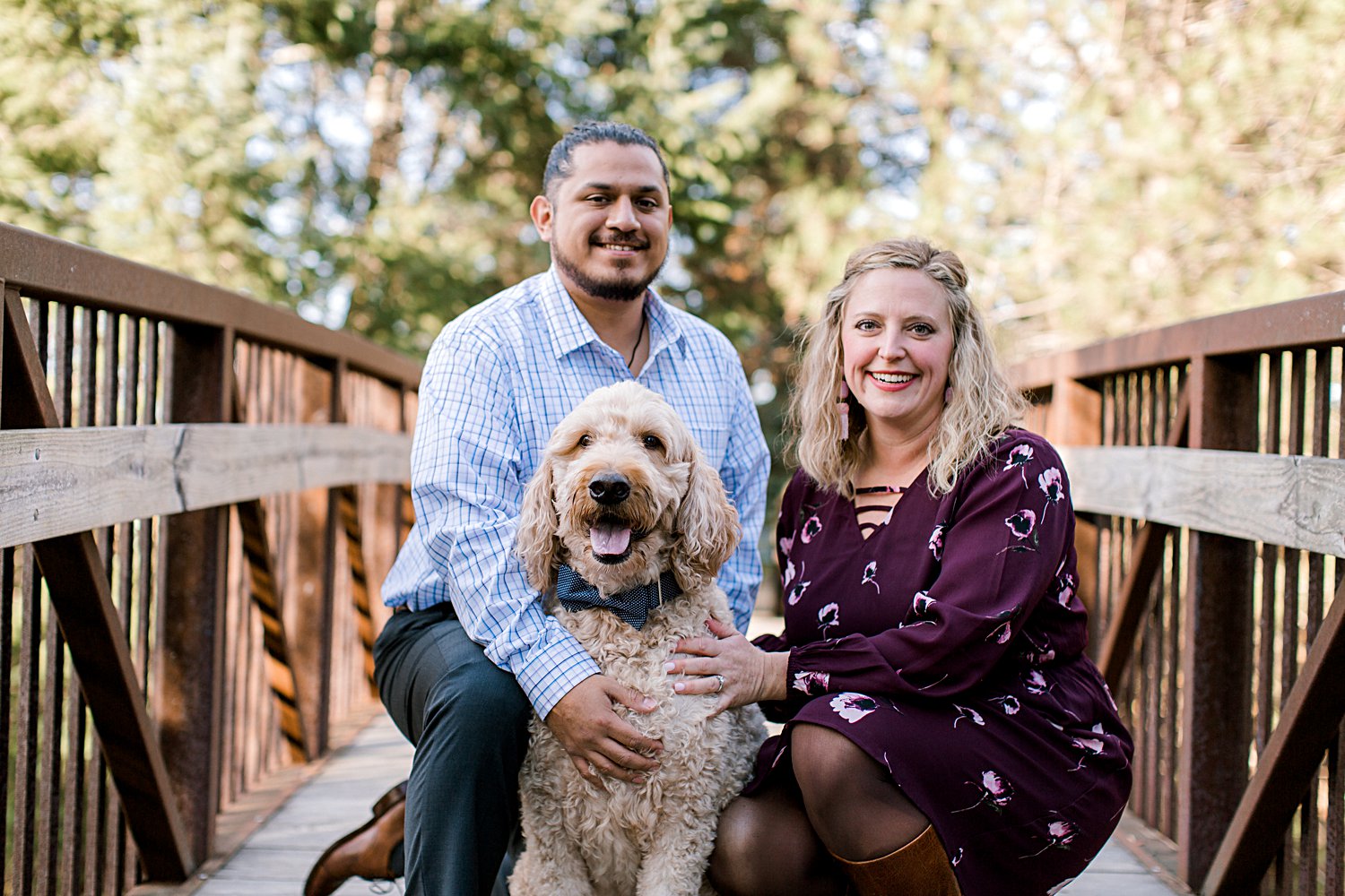 couple smiling with their dog during their engagement session