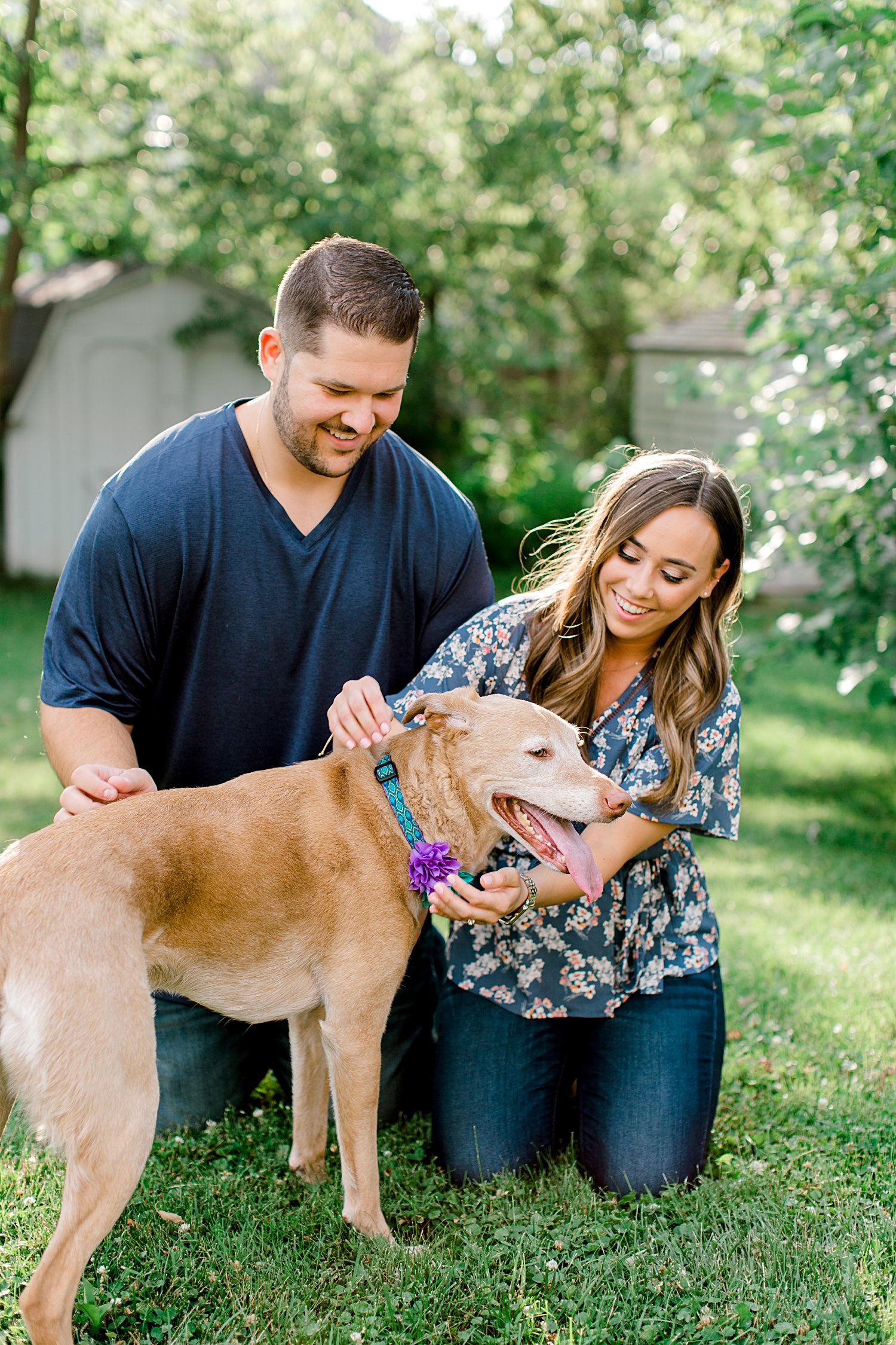 couple petting their dog during their engagement session